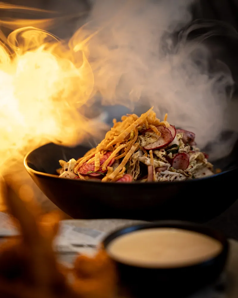 A bowl brought to the table with flame and smoke