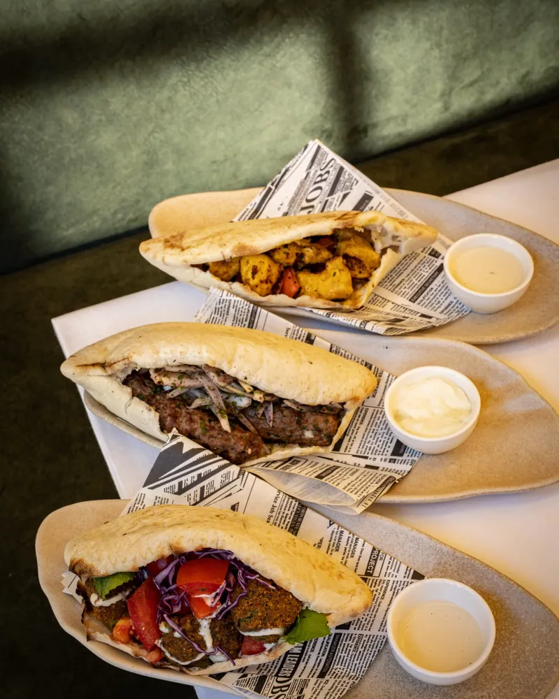 Three Mediterranean pitas on the green velvet banquette
